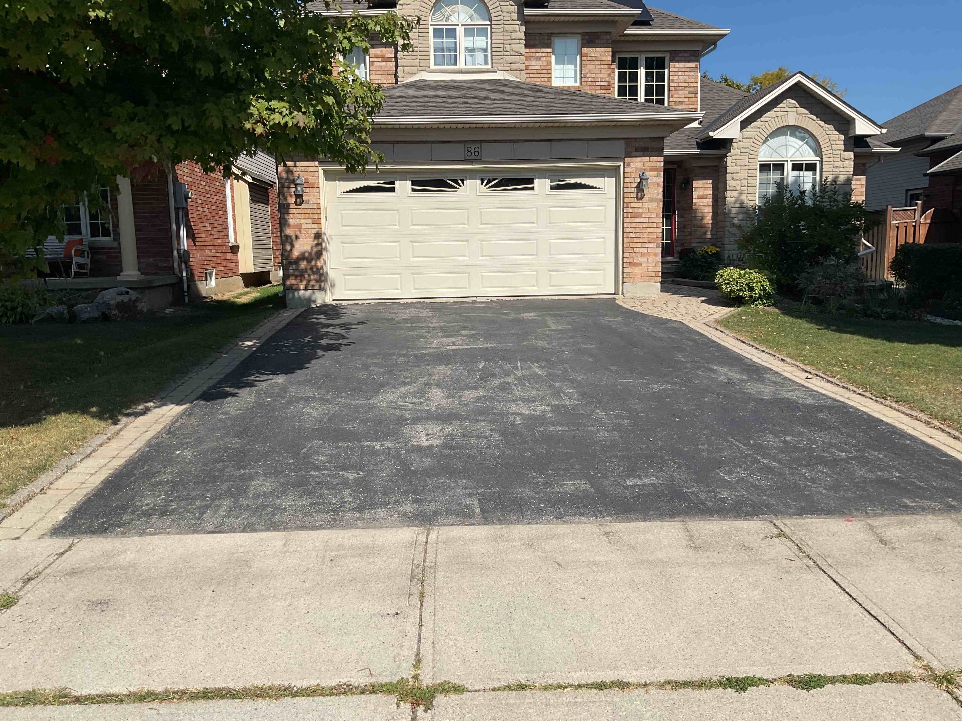 Worn large driveway in Burlington before asphalt sealing service